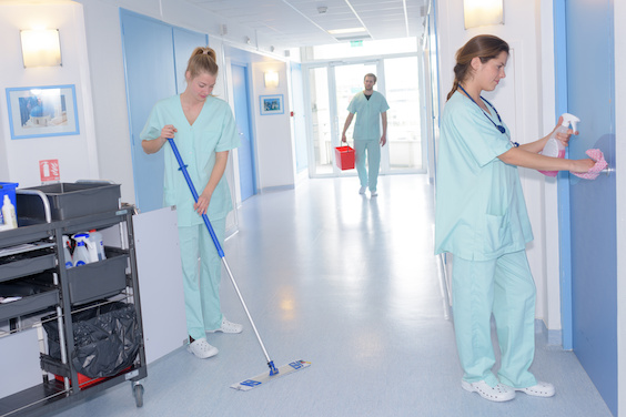 janitors with mop and uniform cleaning hospitals corridor